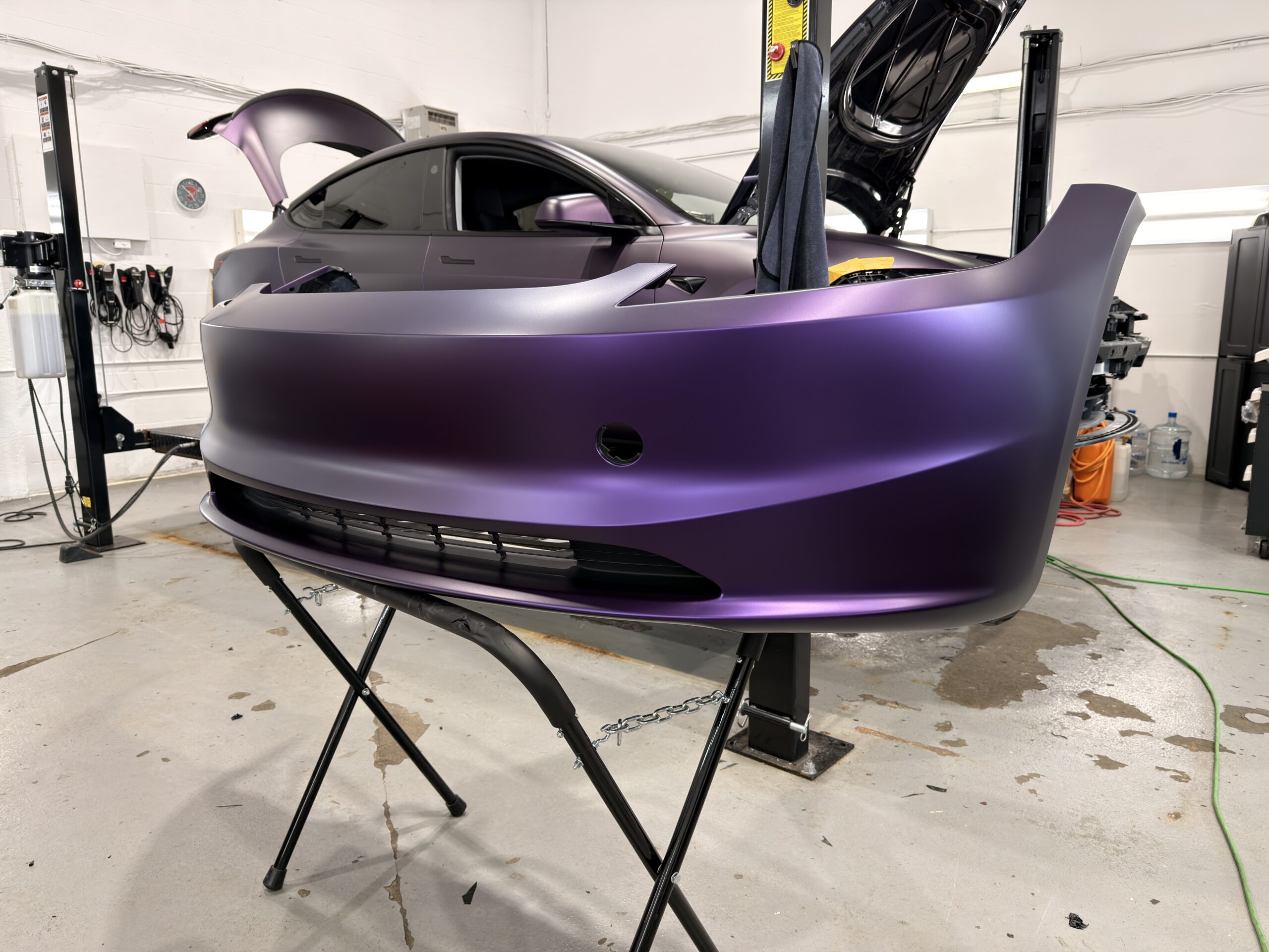 Vinyl wrap installation in progress, film being laid over a painted panel