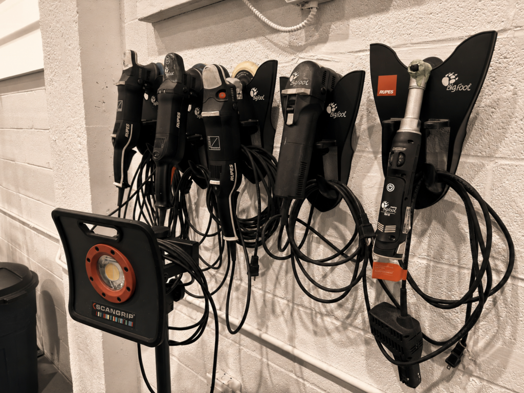 Wall-mounted Rupes polishing machines and a Scangrip inspection light in the detailing studio