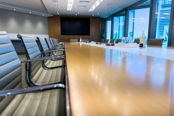 Modern commercial boardroom with floor-to-ceiling windows and urban skyline views for office window tinting applications