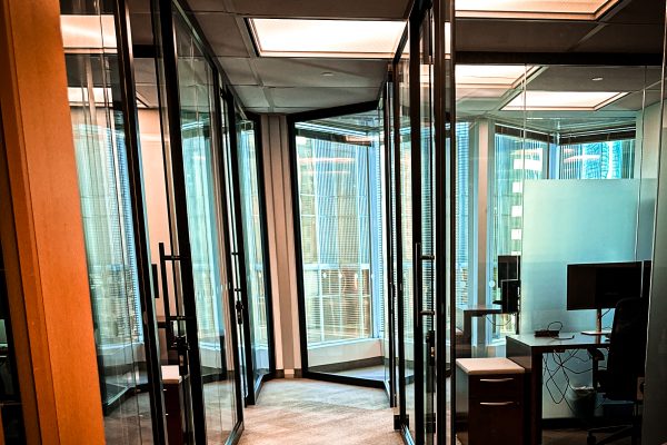 Modern commercial office interior with architectural window film and partially frosted glass office partitions in a high-rise workspace